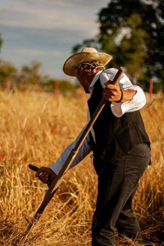 a man is dressed in black and is holding a shovel