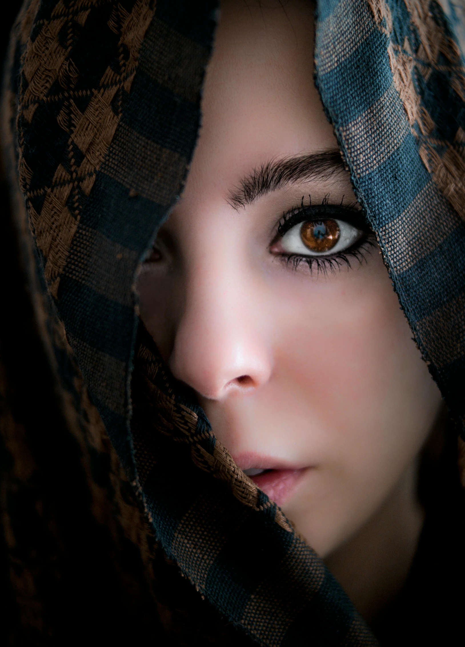 a woman peeking out from under her blanket