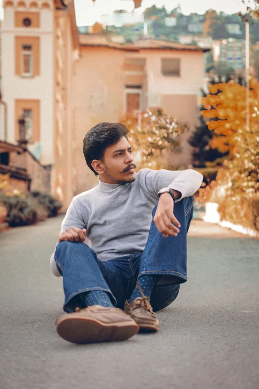 a man sitting on the ground with his legs crossed