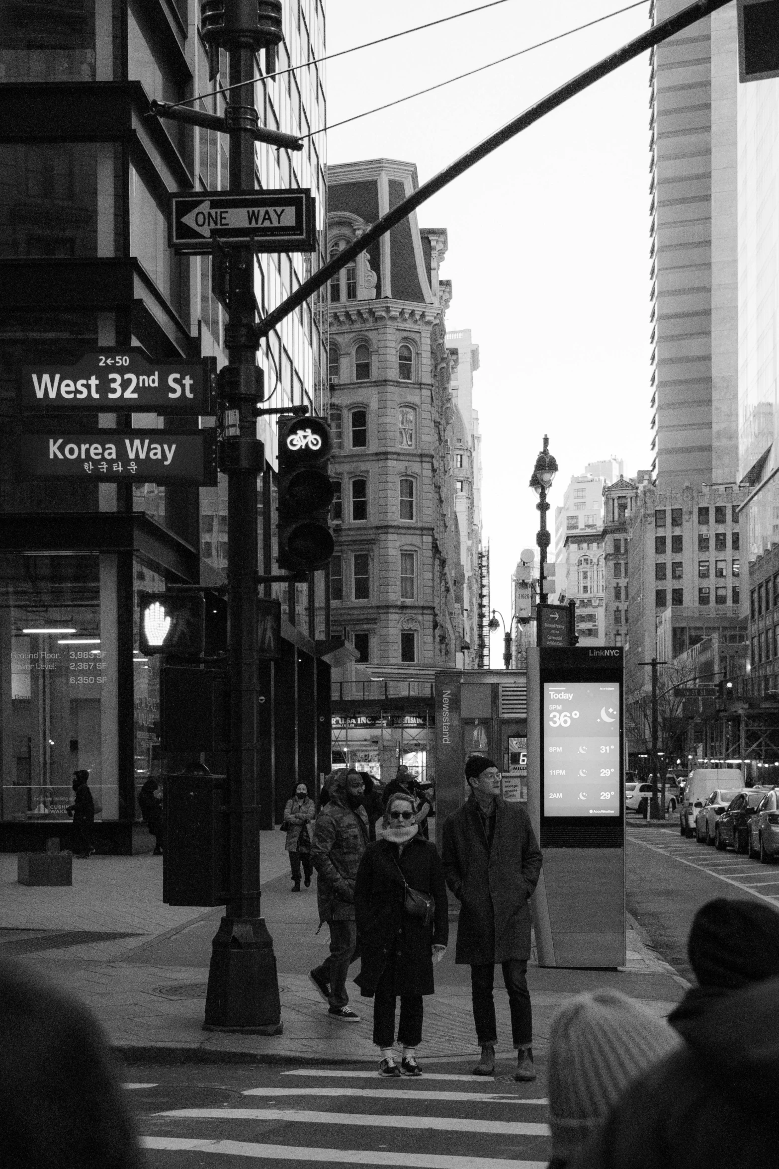 black and white image of people walking down street