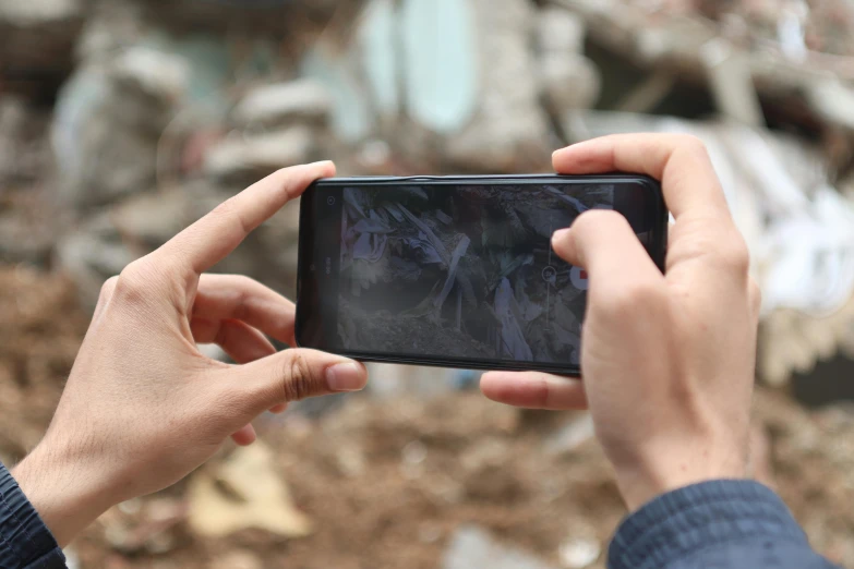 a person holding a cell phone in their hands