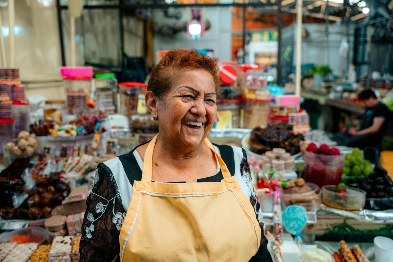 an older woman wearing a yellow bib and holding soing in her hands