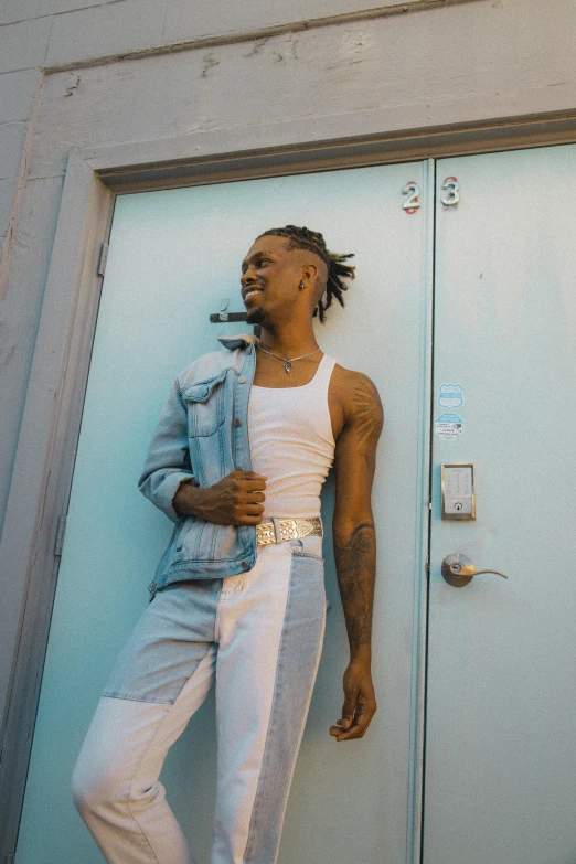 a man with dreadlocks, leaning against the wall