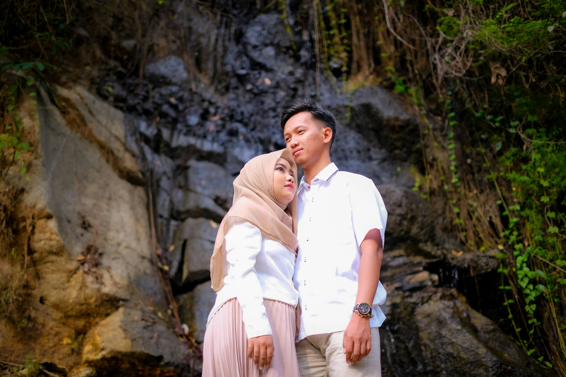 two people in a field near some rocks