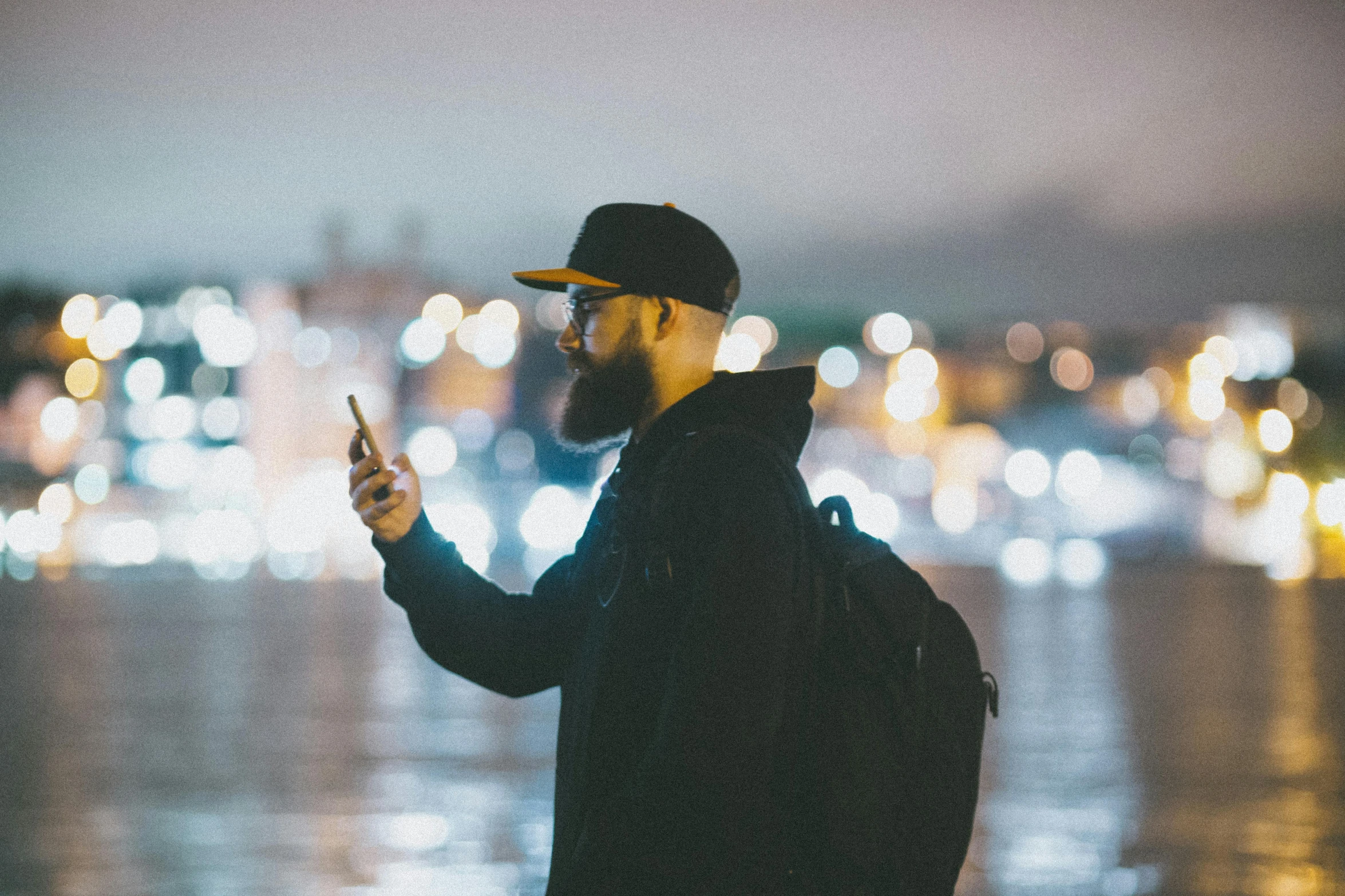 the man is using his phone on the dock