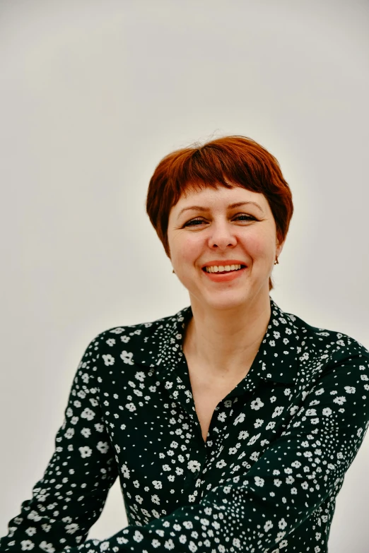 a woman with short red hair in a black and white dress