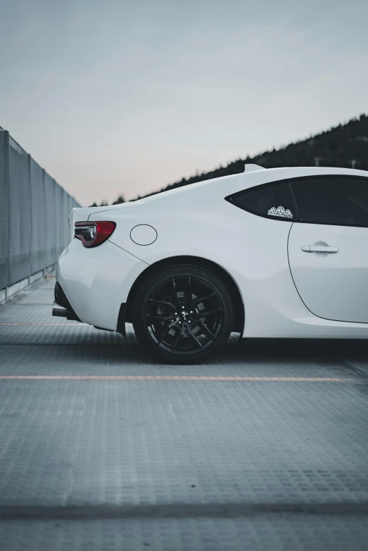 a sports car is seen parked near a fence