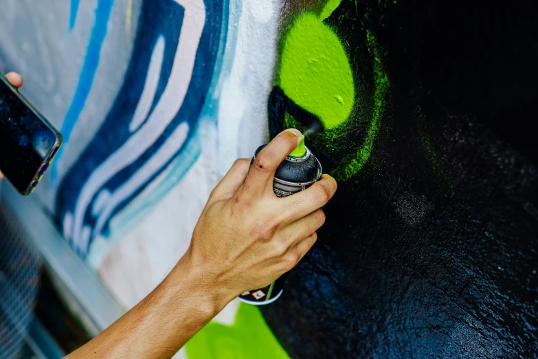 a person with an open cell phone holding a spray bottle