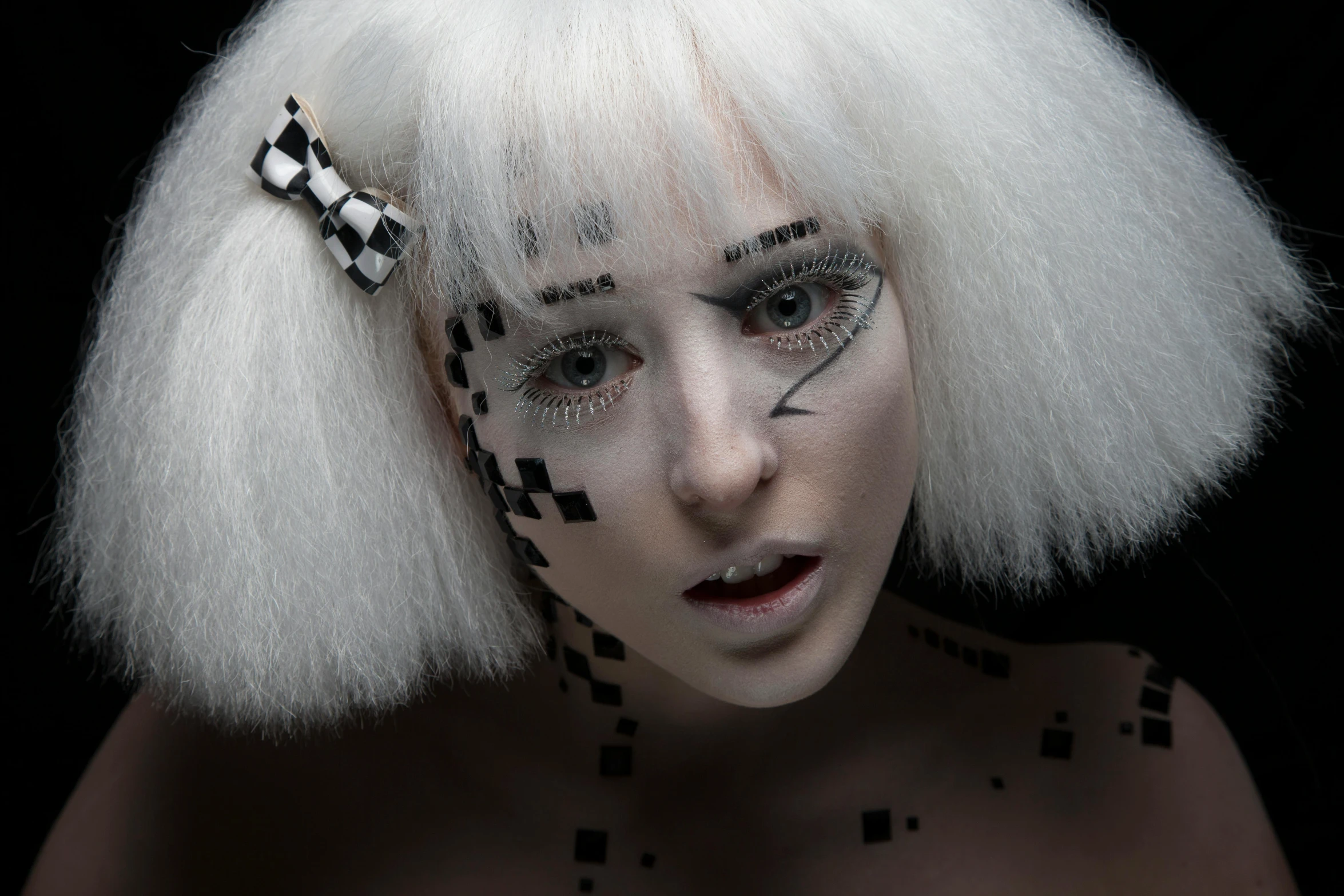 a woman wearing a white wig with black and white designs on it