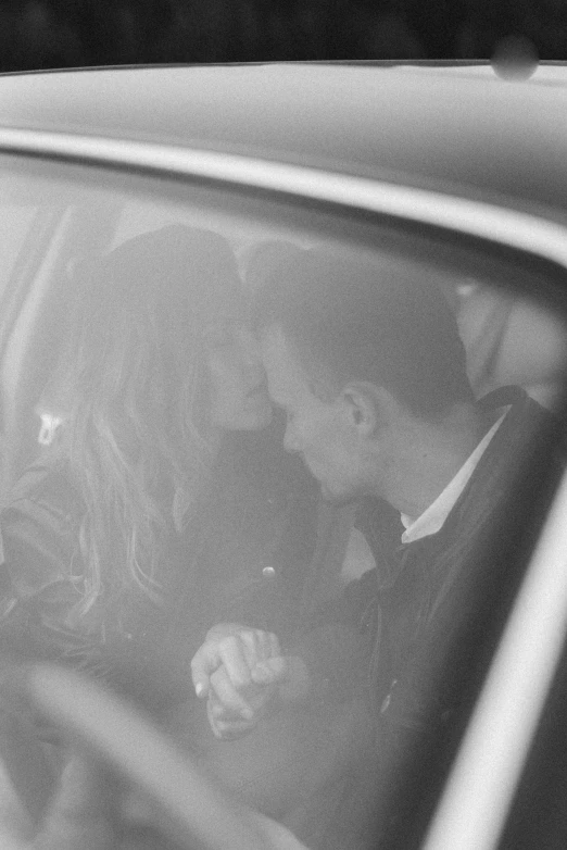 a man and woman in a car in black and white