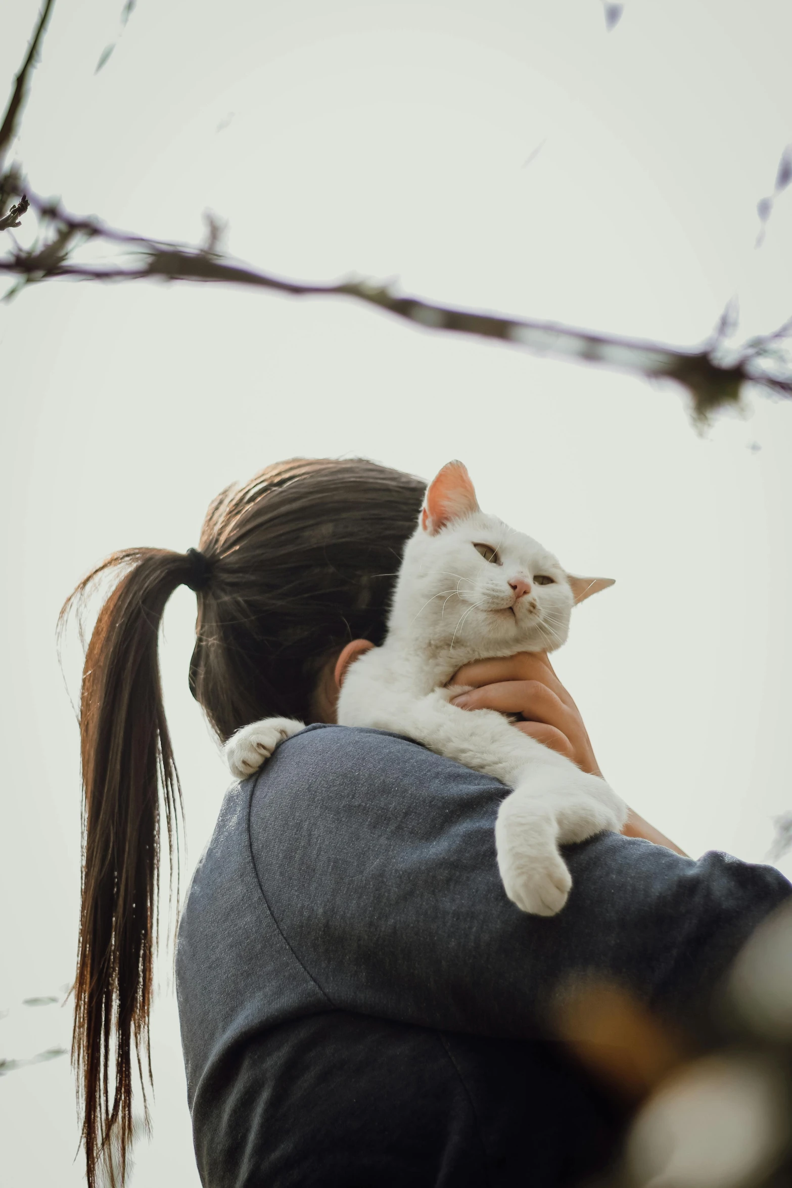 a woman holding a white cat in her arms