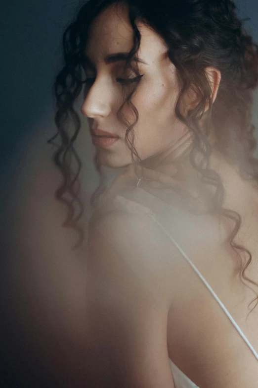 woman looking down with dark hair behind her