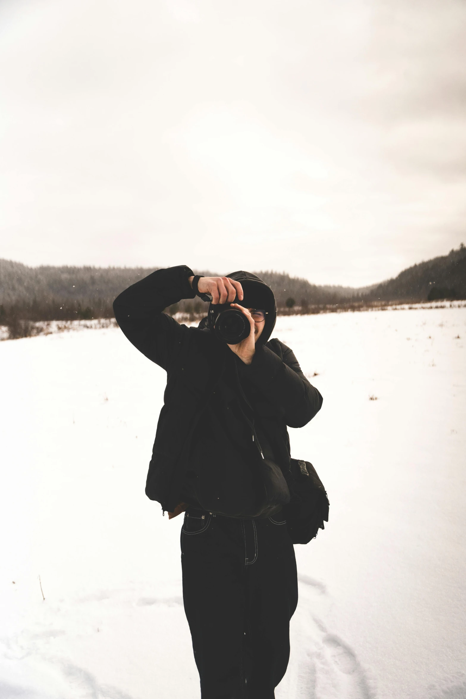 a man wearing a hoody while on the phone in the snow