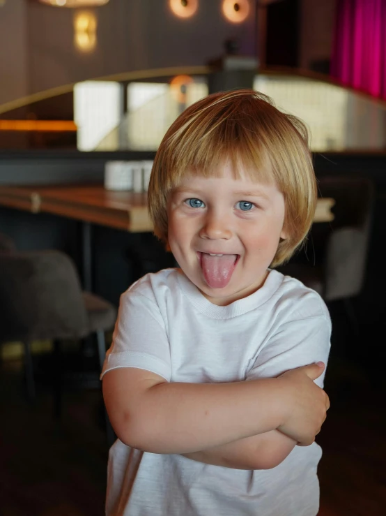  sticking out his tongue and sitting at a table