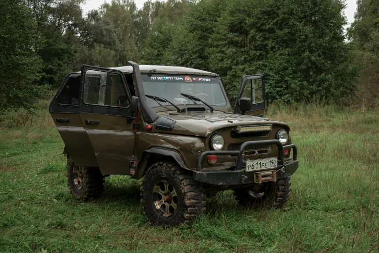 a jeep in a field next to trees