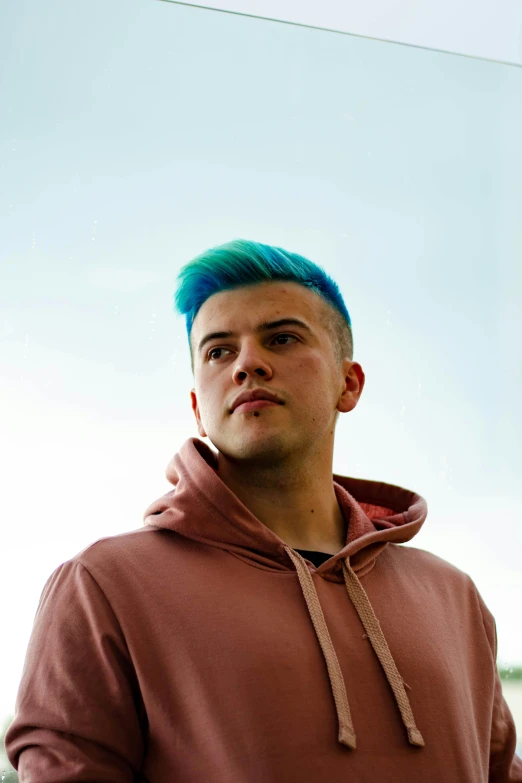 a man with blue hair and a hoodie