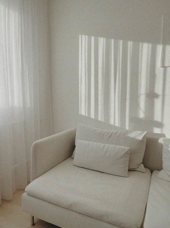 a couch with a white and gray fabric is placed in a living room