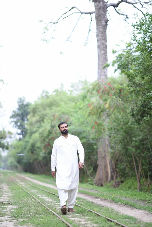 a man walks with an umbrella in hand in the jungle