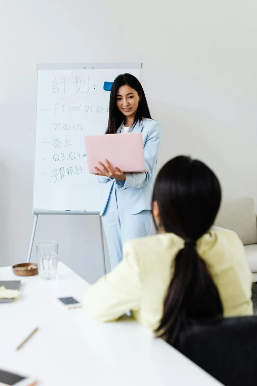 a woman giving a speech in front of her colleagues