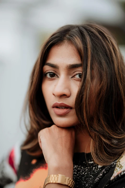 a young woman wearing a gold wrist watch