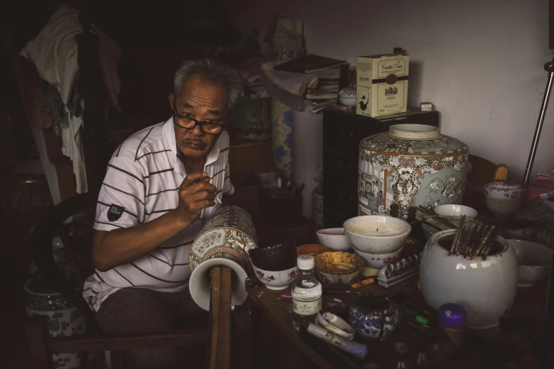 an older man wearing glasses is knitting with yarn