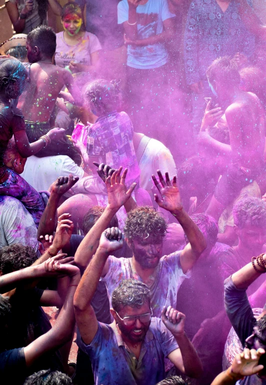 a group of people throwing colored powder at each other