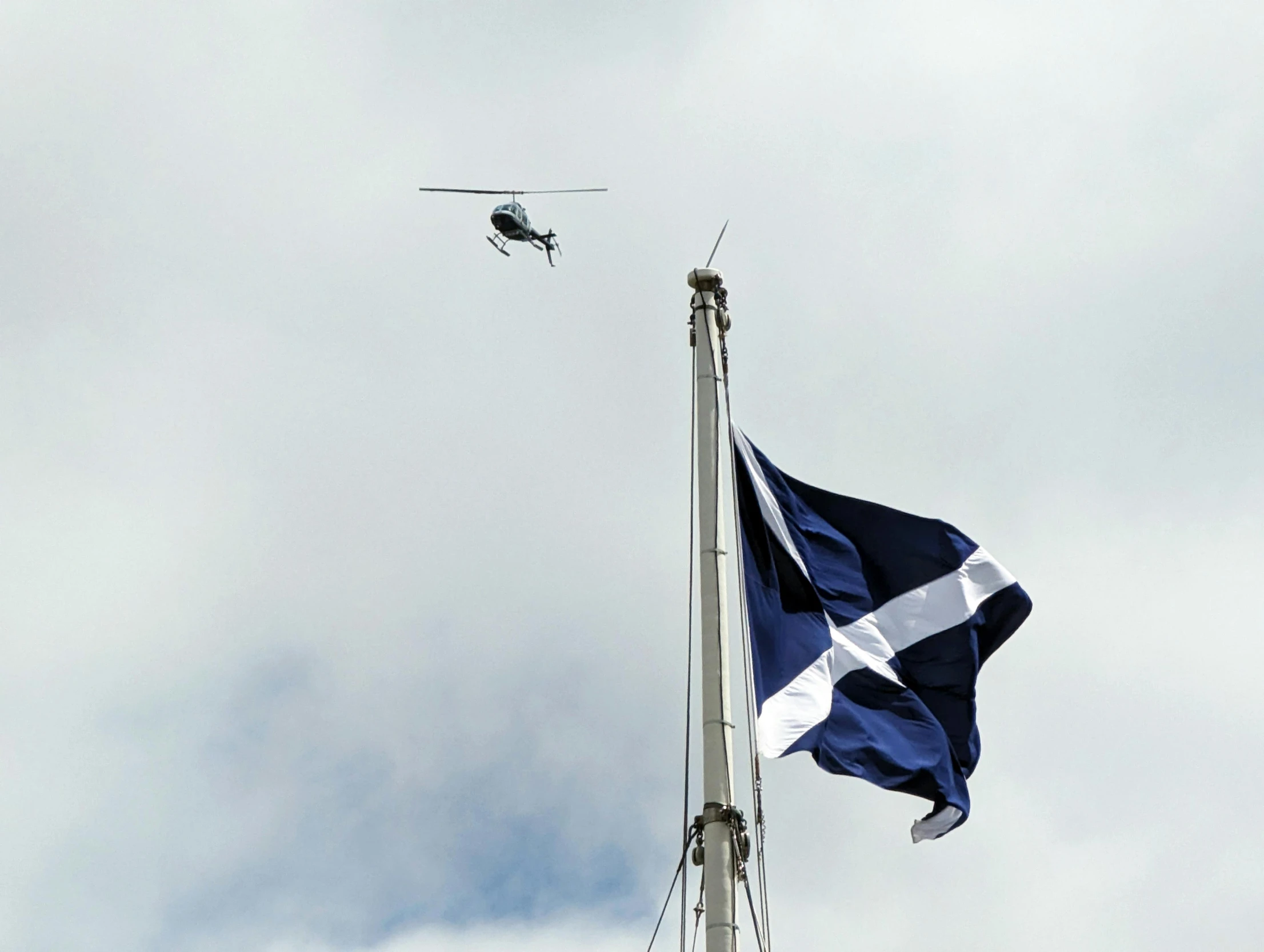 an helicopter flying above a blue and white flag