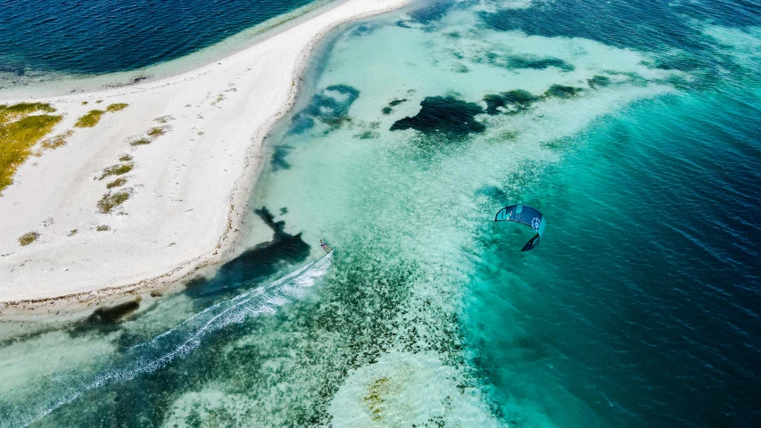 a boat is floating out on the water near the sand