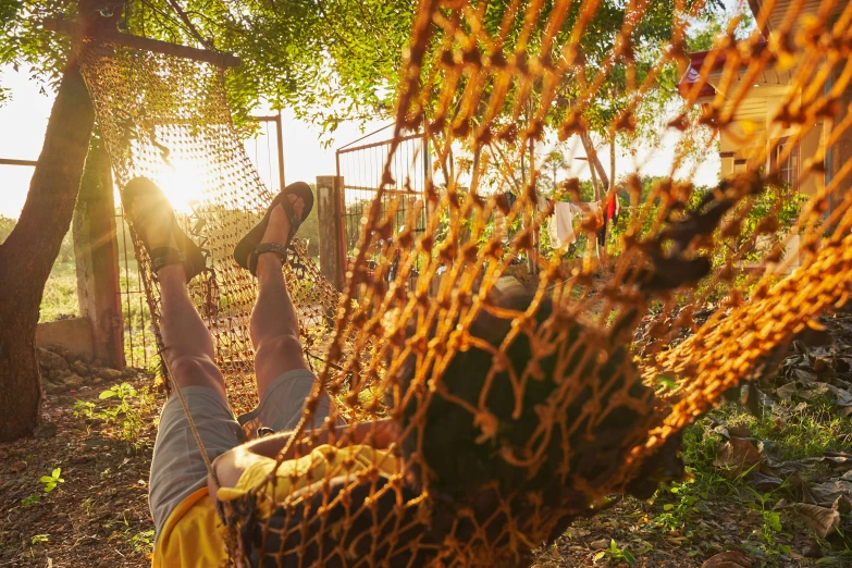 person in orange scarf hanging upside down in hammock