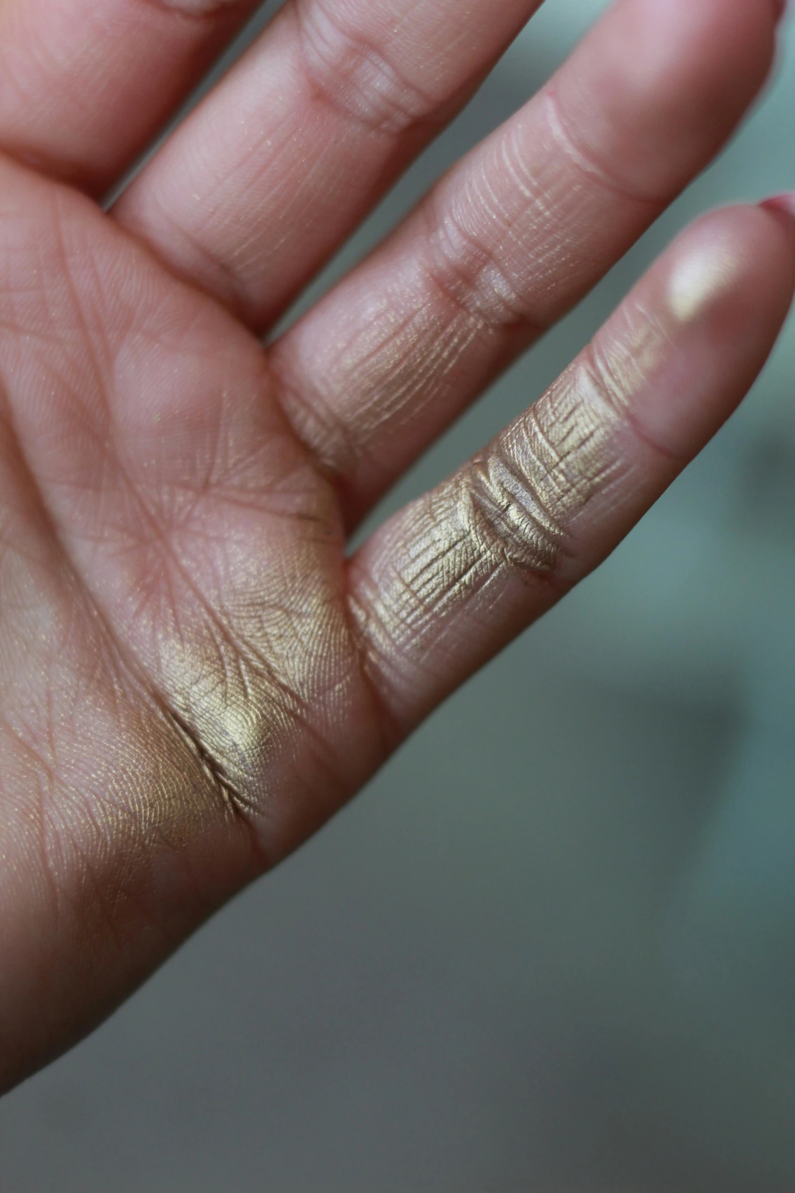 a close - up of a persons hand with gold paint