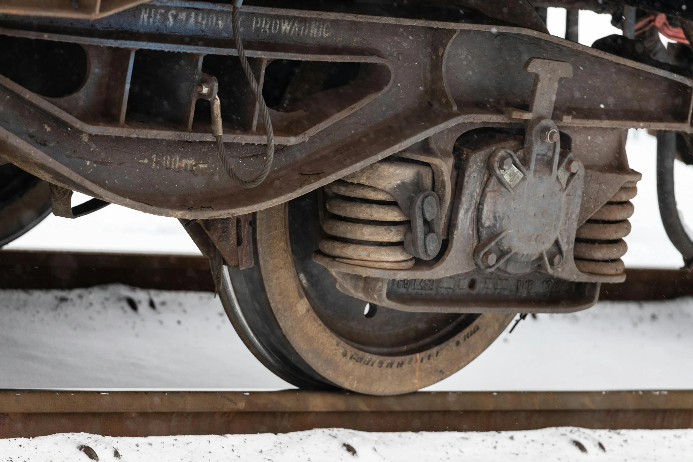 wheels and spokes of a train with snow on the ground