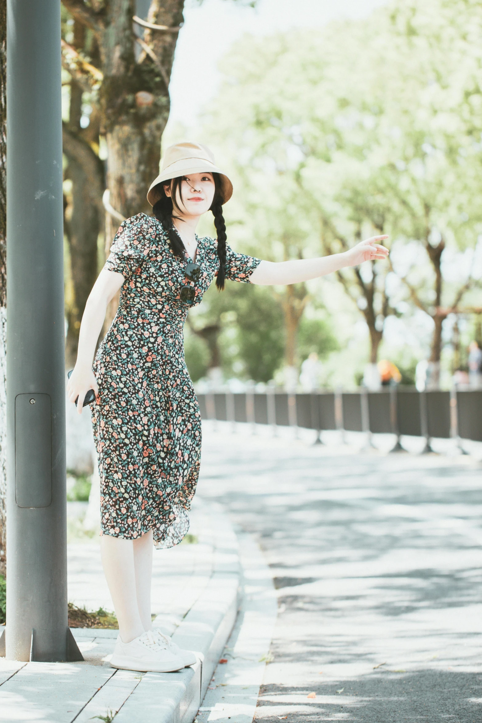 a woman is posing next to a tree wearing a dress