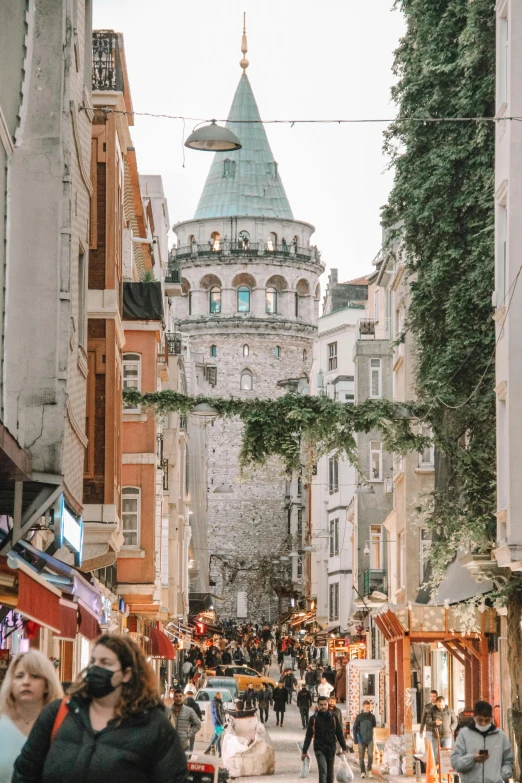 pedestrians walking through crowded street with lots of tall buildings