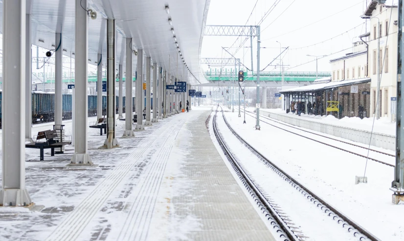 the view of a snowy platform in an outdoor train station