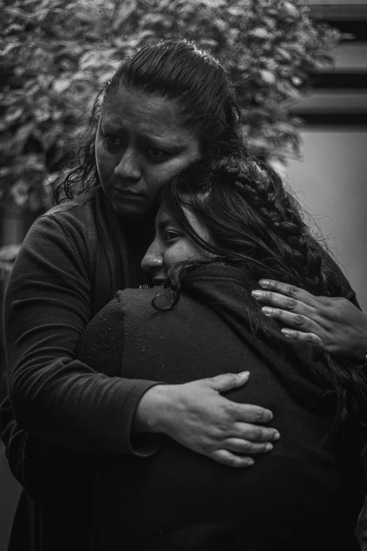 a woman holding a baby who has her arm around her