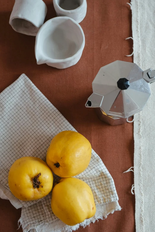 three ripe fruit sitting on top of a cloth