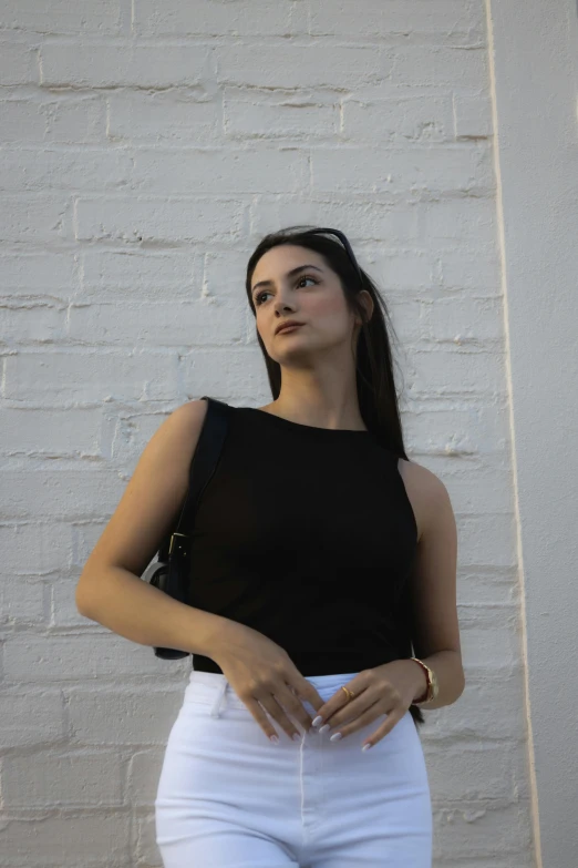 young woman wearing short white shorts and black top posing