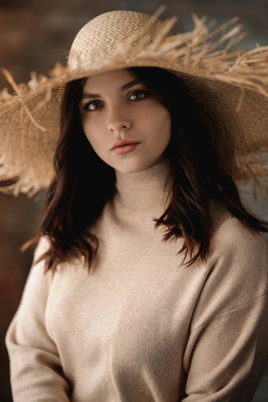 woman wearing large hat over shoulder while looking at camera