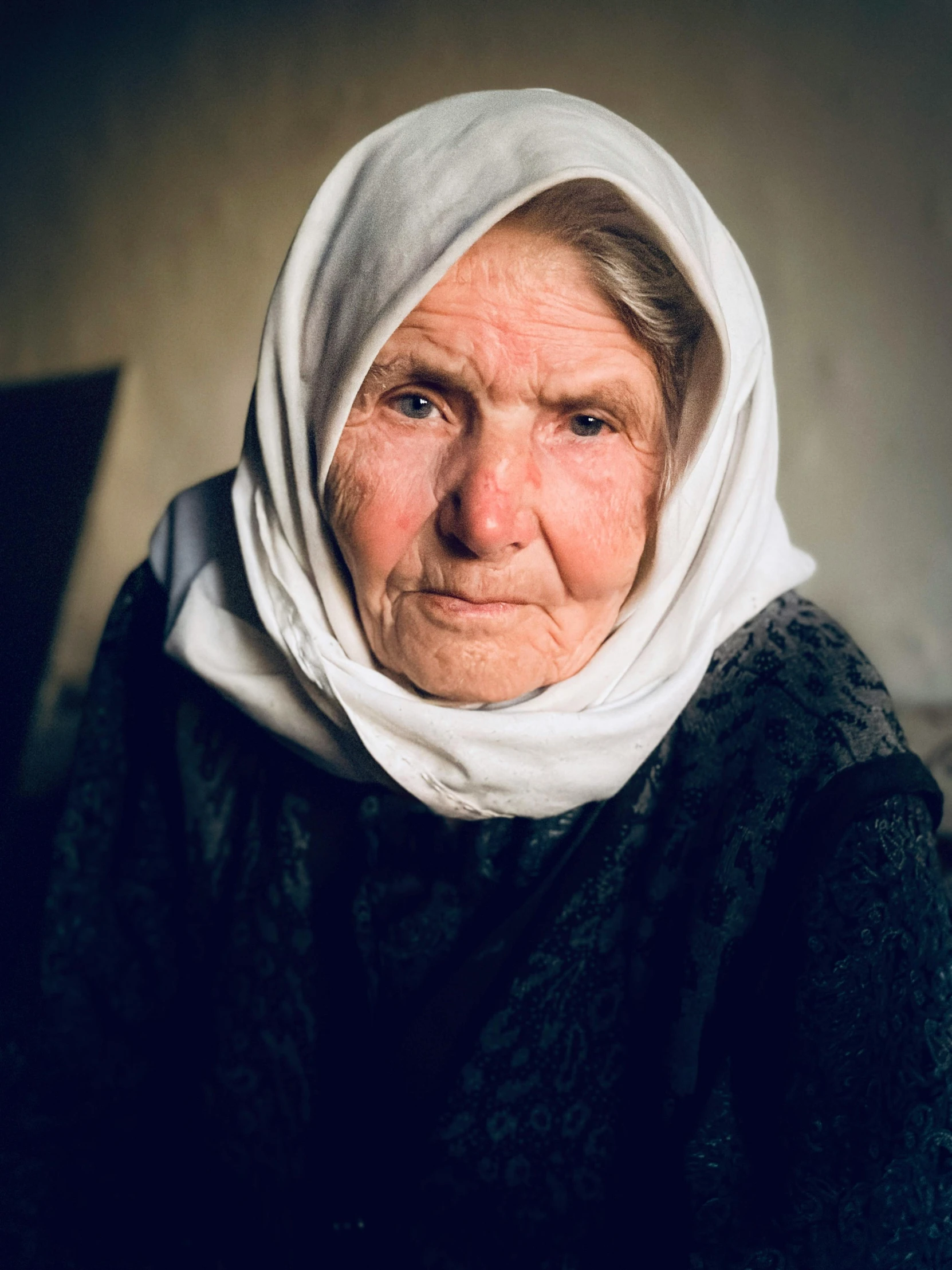 an old woman with a white scarf on her head