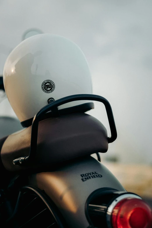 white helmet on back of a silver and black motorcycle