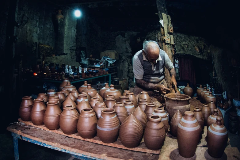 a man working on some big clay pots