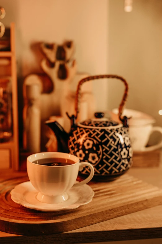 a cup of coffee with a tea kettle in the background