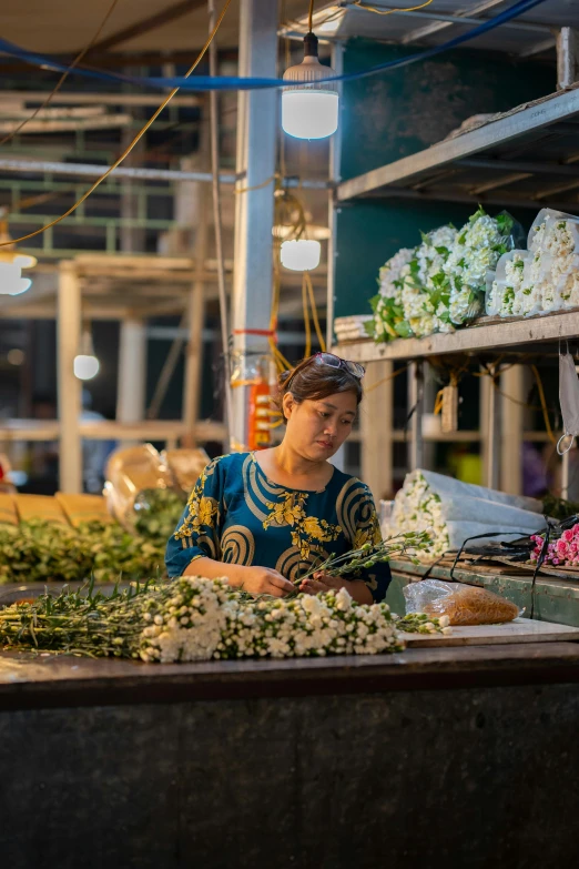 a woman is working on plants at an outdoor market