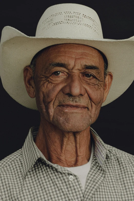 an old man wearing a cowboy hat poses for the camera