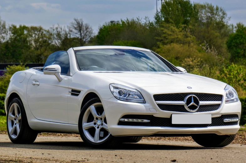 a white mercedes cls cab is parked on the dirt