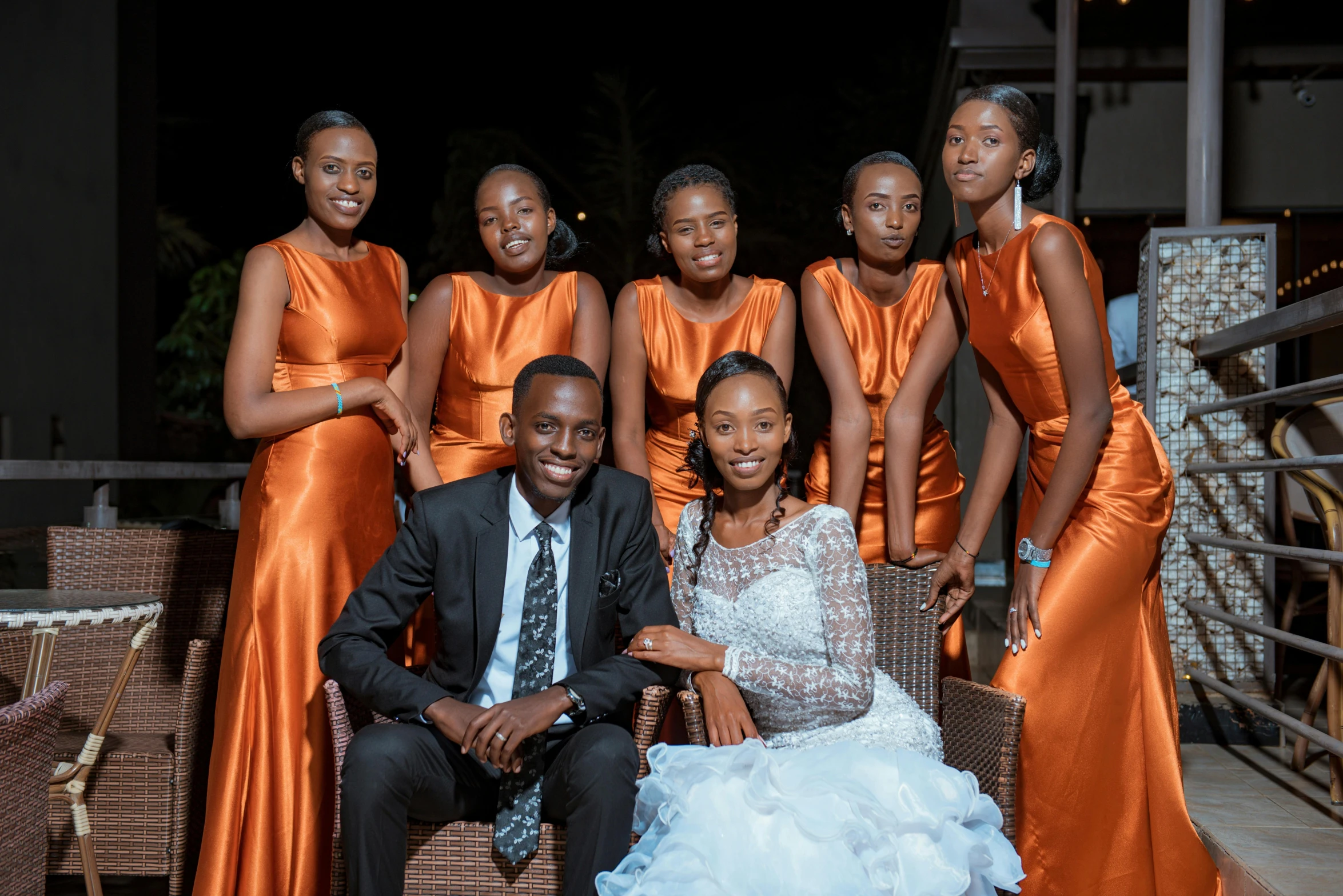 the bride and groom are sitting on the arm of a woman