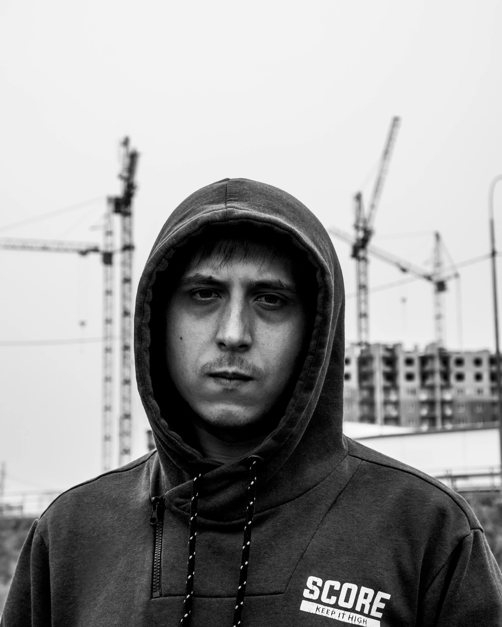 a man in black hoodie in front of construction