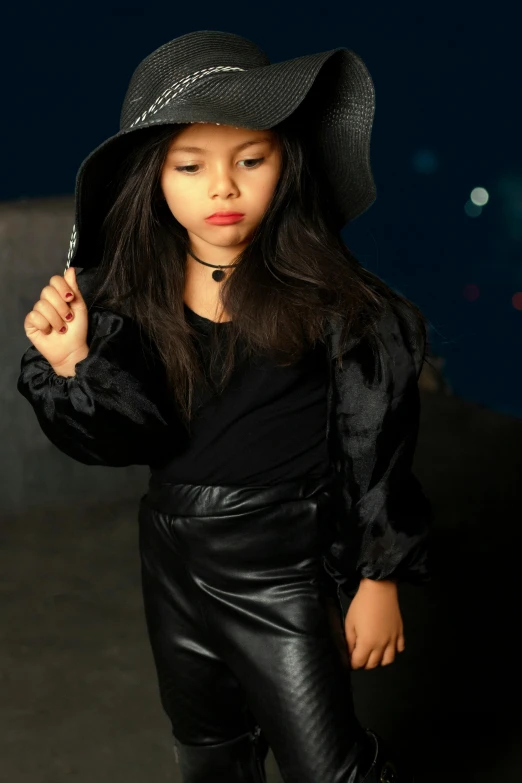 a little girl is posing with a hat