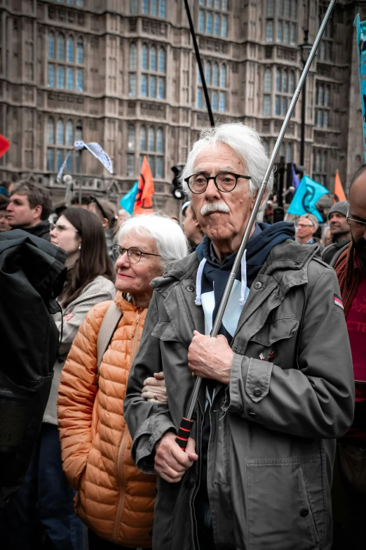 a group of older people holding flag poles on a street