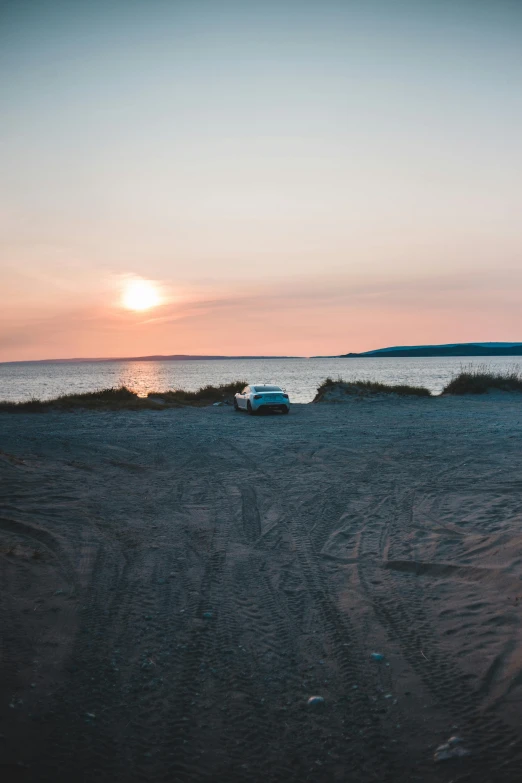 a car parked on the shore of a beach